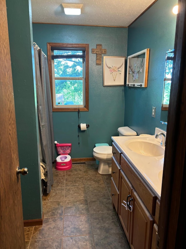 bathroom featuring vanity, toilet, and a textured ceiling