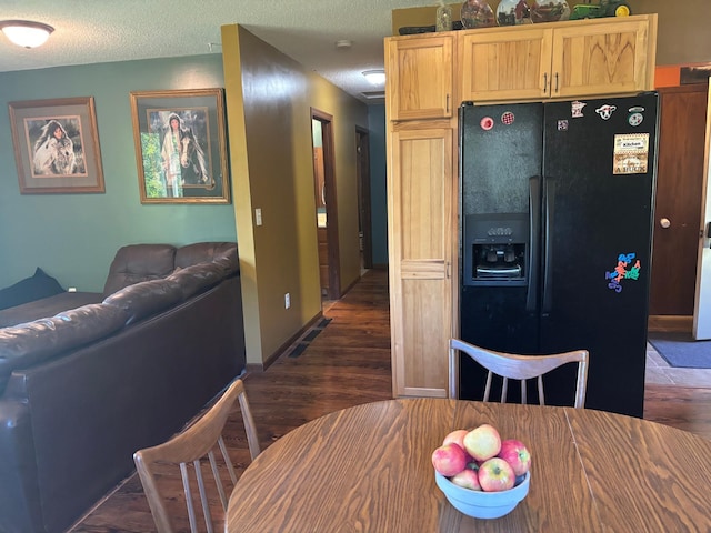 kitchen featuring light brown cabinets, a textured ceiling, black refrigerator with ice dispenser, and dark hardwood / wood-style flooring