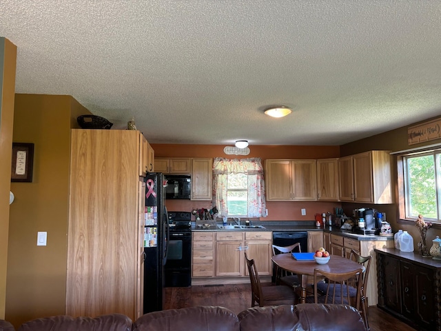 kitchen with a textured ceiling, black appliances, and sink