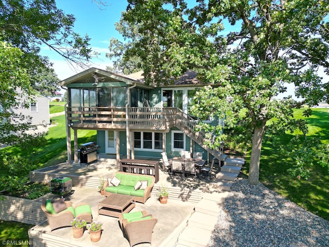 back of house with a sunroom, stairs, a wooden deck, a patio area, and an outdoor living space