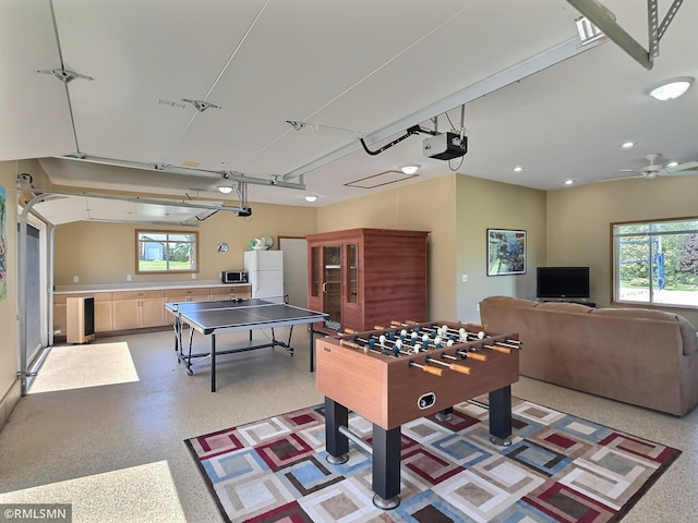 rec room featuring a garage, plenty of natural light, and light speckled floor