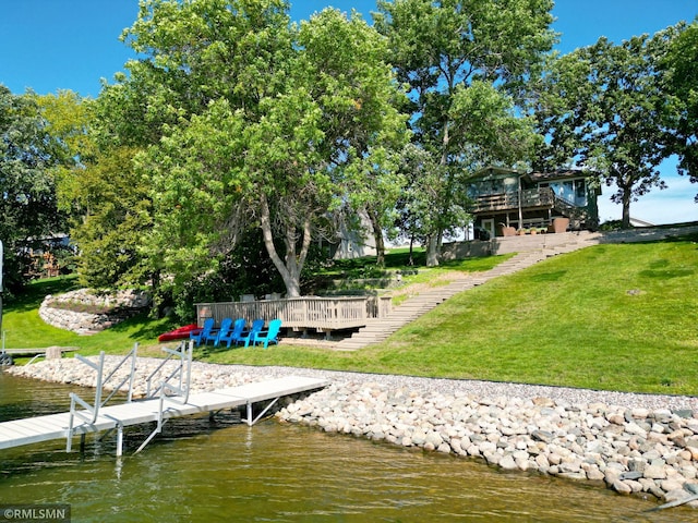 view of dock featuring a deck with water view, a yard, and stairs