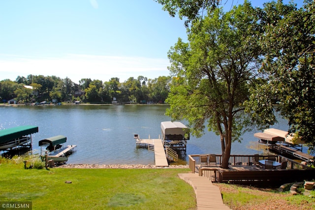 view of dock featuring a water view, a lawn, and boat lift