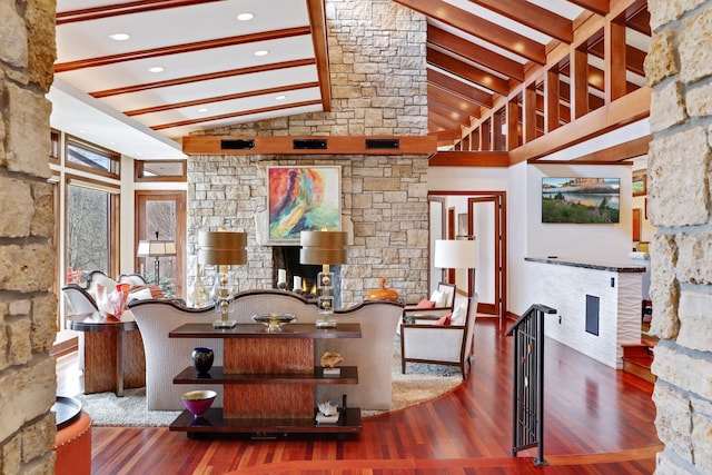 living room with a wealth of natural light, high vaulted ceiling, and hardwood / wood-style flooring