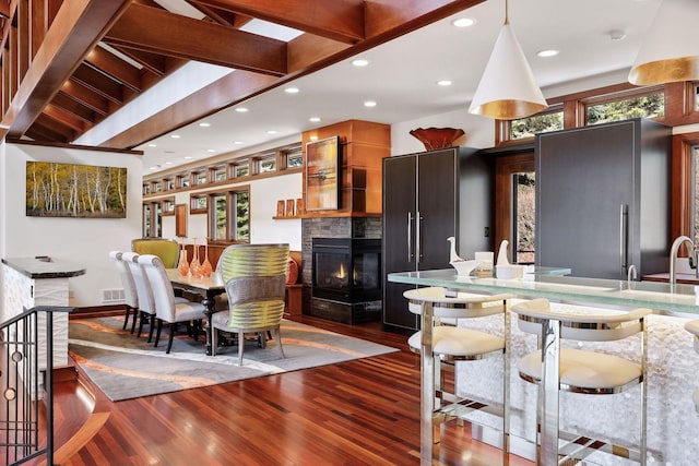 dining room with a multi sided fireplace and hardwood / wood-style flooring