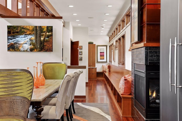 dining space with a multi sided fireplace and hardwood / wood-style floors