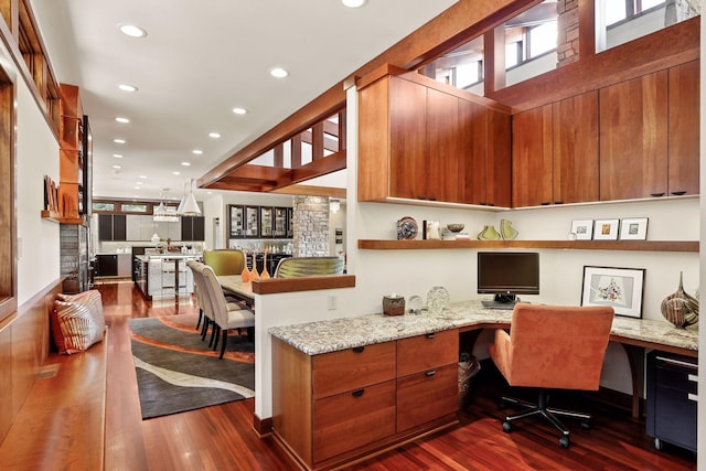 office with built in desk and dark hardwood / wood-style flooring