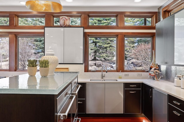 kitchen featuring sink, light stone counters, and tasteful backsplash