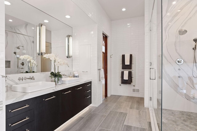 bathroom featuring walk in shower, tile walls, and vanity