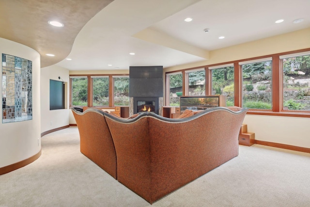 living room featuring a fireplace, light colored carpet, and plenty of natural light