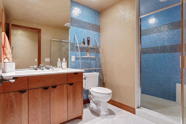 bathroom featuring a tile shower, vanity, toilet, and tile patterned floors