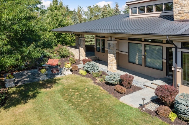 rear view of house with a lawn and a patio