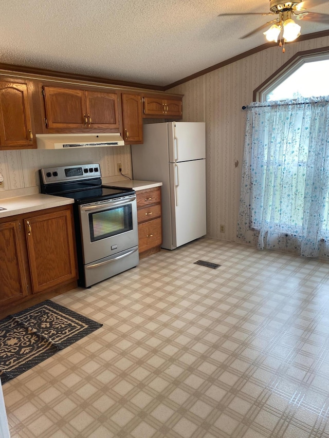 kitchen featuring white fridge, ornamental molding, a textured ceiling, ceiling fan, and electric range