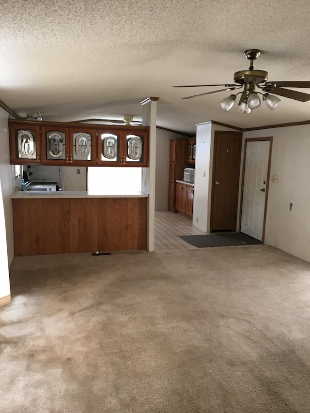 kitchen with carpet flooring, ceiling fan, kitchen peninsula, and a textured ceiling