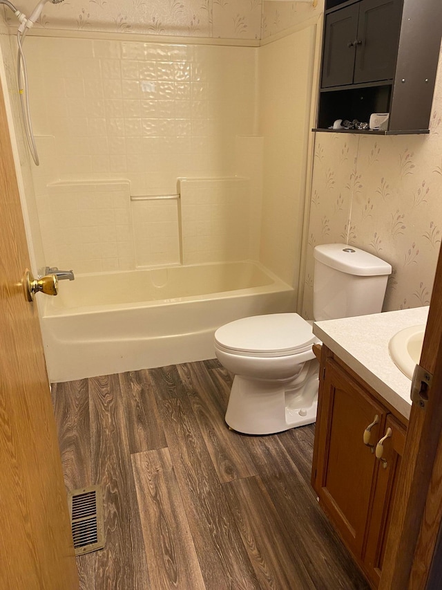 full bathroom featuring vanity, toilet, wood-type flooring, and washtub / shower combination