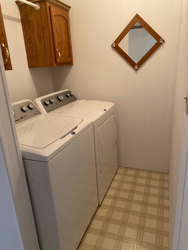 laundry area with cabinets and washer and clothes dryer