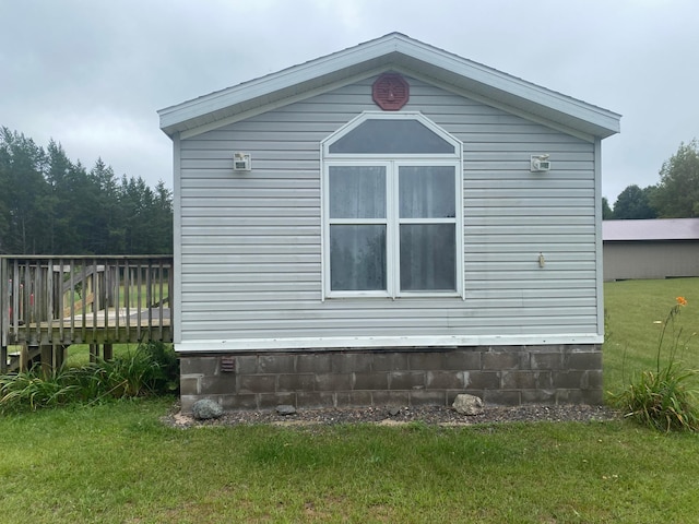 view of home's exterior featuring a lawn and a deck