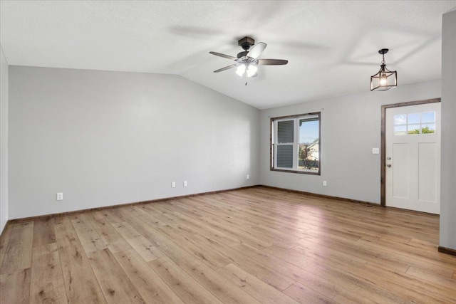 interior space with ceiling fan, lofted ceiling, and light hardwood / wood-style flooring