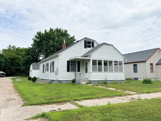 bungalow-style home with a front yard, driveway, and a chimney