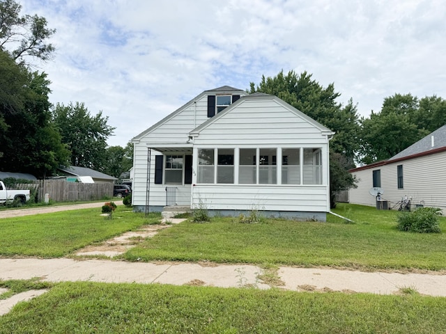 bungalow-style home featuring a sunroom and a front lawn