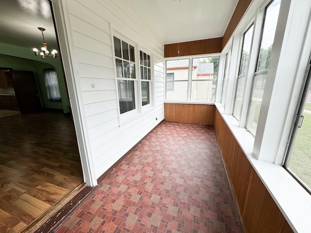 unfurnished sunroom featuring an inviting chandelier