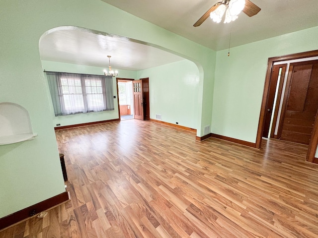 unfurnished room featuring hardwood / wood-style flooring and ceiling fan with notable chandelier