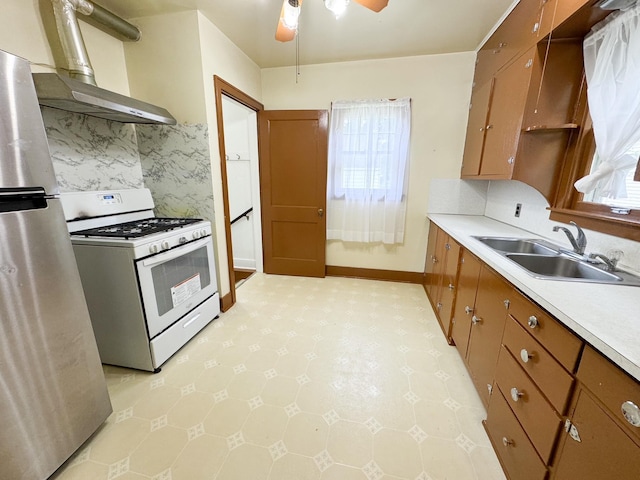 kitchen featuring ceiling fan, sink, gas range gas stove, and a healthy amount of sunlight