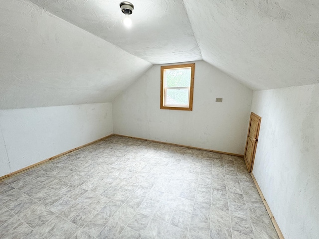 bonus room with a textured ceiling and lofted ceiling