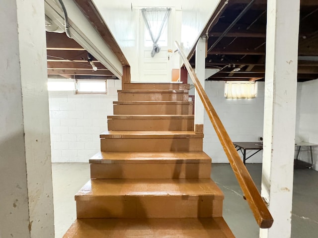 stairs featuring concrete flooring