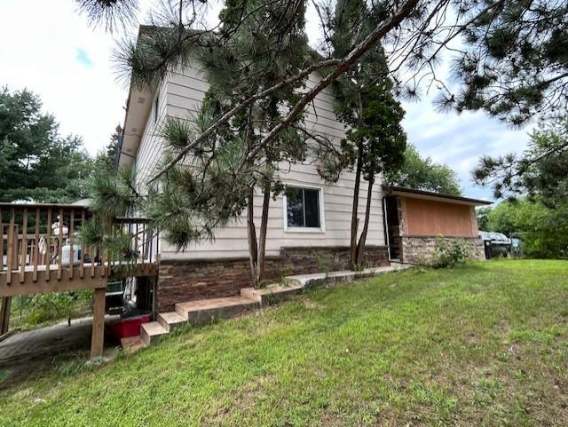 back of property featuring a deck and a yard