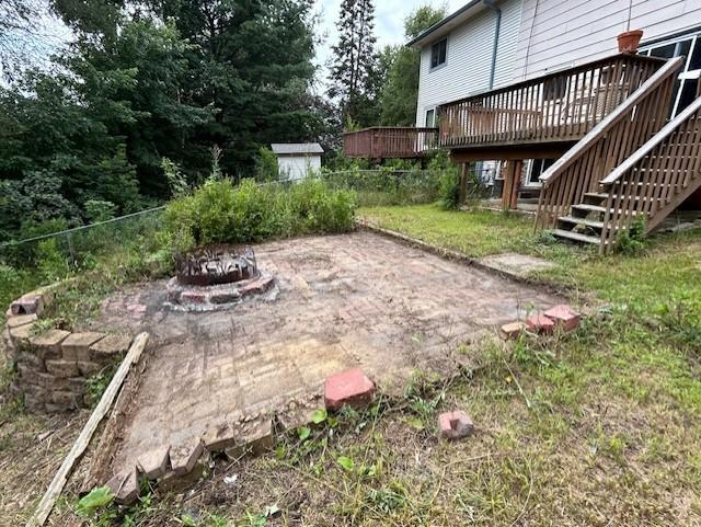 view of yard featuring a fire pit, a wooden deck, and a patio