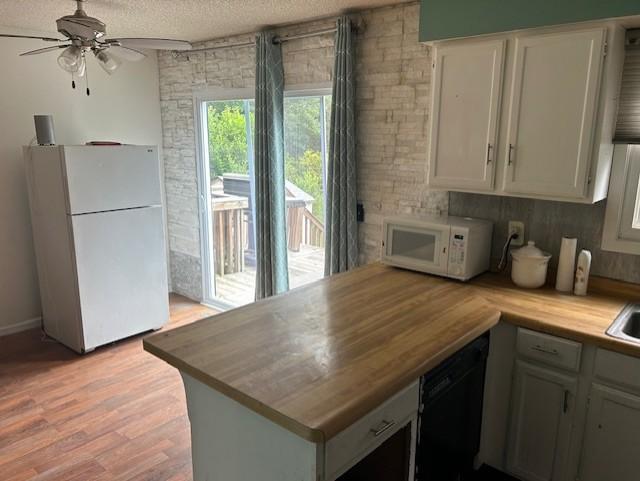 kitchen featuring ceiling fan, white appliances, wood counters, light hardwood / wood-style flooring, and a textured ceiling