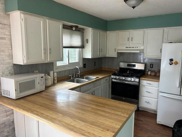 kitchen featuring sink, white cabinetry, a textured ceiling, and white appliances