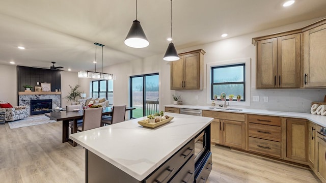 kitchen with hanging light fixtures, a healthy amount of sunlight, sink, and a kitchen island