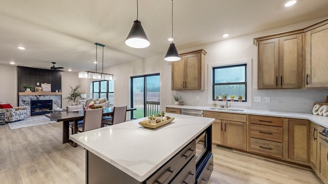 1701 20th Ave Circle NE, Kasson, MN 55944 - kitchen featuring a sink, light wood-type flooring, recessed lighting, a premium fireplace, and a kitchen island