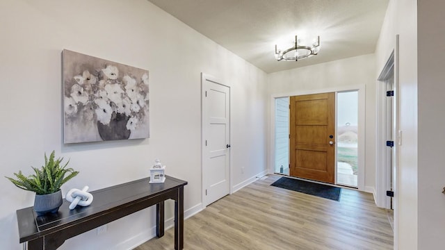 foyer featuring an inviting chandelier and light wood-type flooring