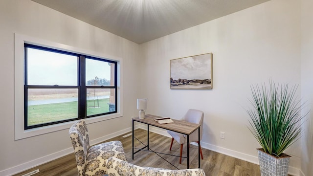 office with dark hardwood / wood-style flooring and a water view