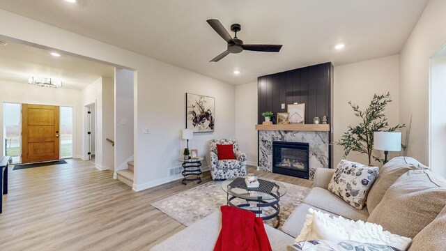 1701 20th Ave Circle NE, Kasson, MN 55944 - living area with light wood finished floors, a premium fireplace, baseboards, recessed lighting, and a ceiling fan