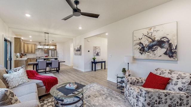 living room featuring light hardwood / wood-style floors and ceiling fan