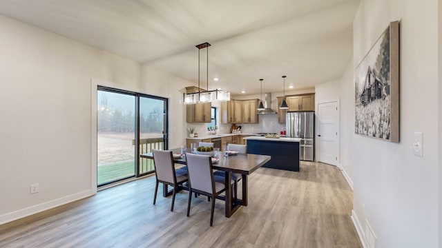 dining space featuring light wood-type flooring and sink