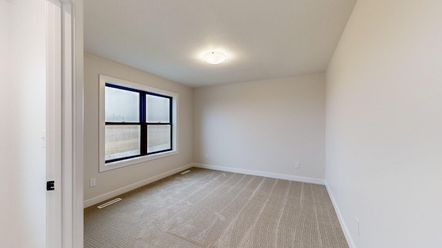 unfurnished room with light carpet