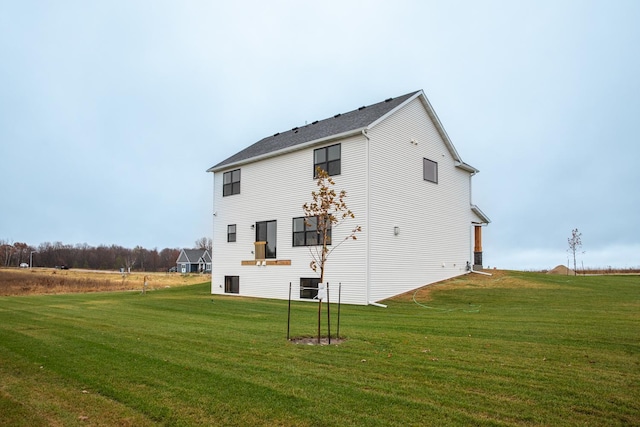 rear view of property featuring central air condition unit and a lawn