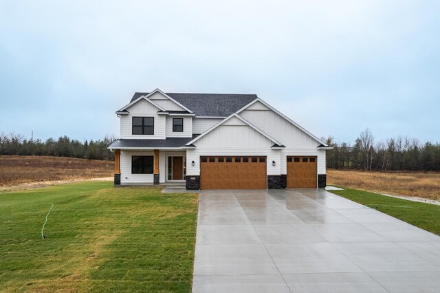 1701 20th Ave Circle NE, Kasson, MN 55944 - view of front of house with a front lawn, driveway, roof with shingles, a garage, and board and batten siding