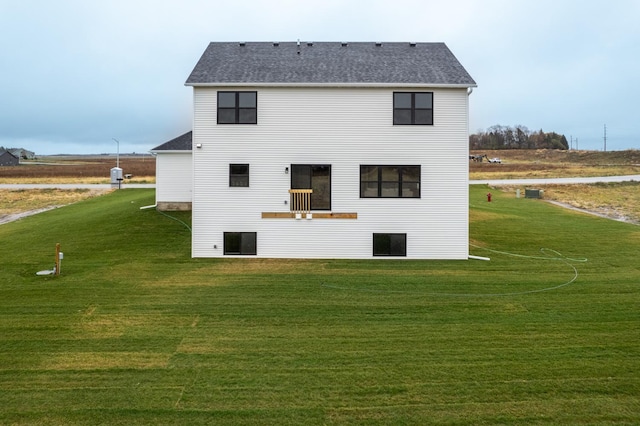 back of house featuring a lawn