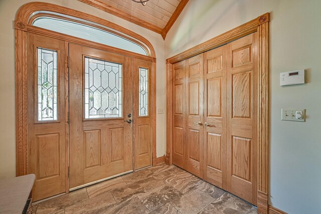 entryway with vaulted ceiling and ornamental molding