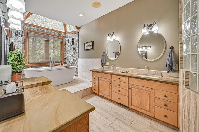 bathroom featuring a tub, vanity, and tile walls