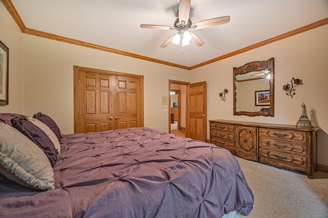 bedroom with ornamental molding, carpet, ceiling fan, and a closet