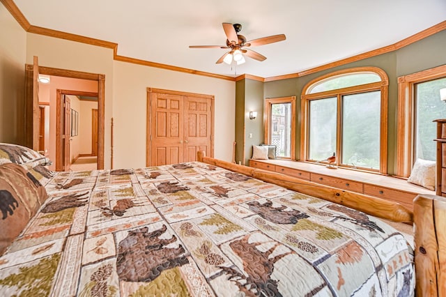 bedroom with ornamental molding, multiple windows, ceiling fan, and a closet