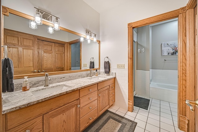 bathroom with vanity, tile walls, tile patterned flooring, and a bathtub