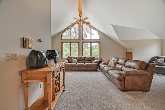 carpeted living room featuring ceiling fan and vaulted ceiling with beams